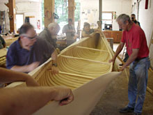 2人で釘うち、キャンバスでカヌーを包む